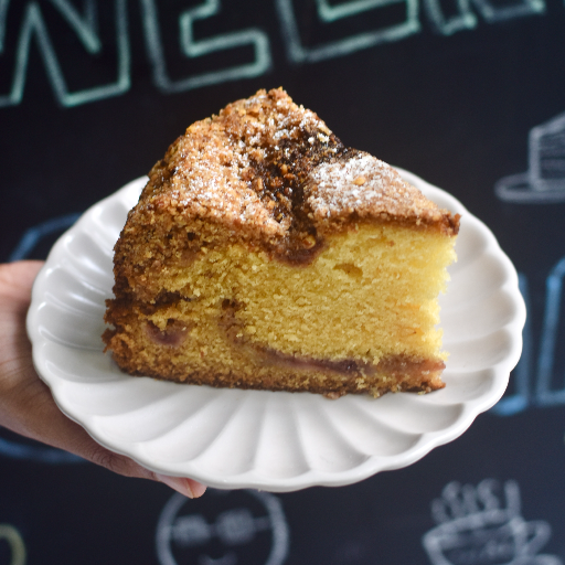 A crumble-topped slice of Banana-Coffee Tea Cake on a white plate